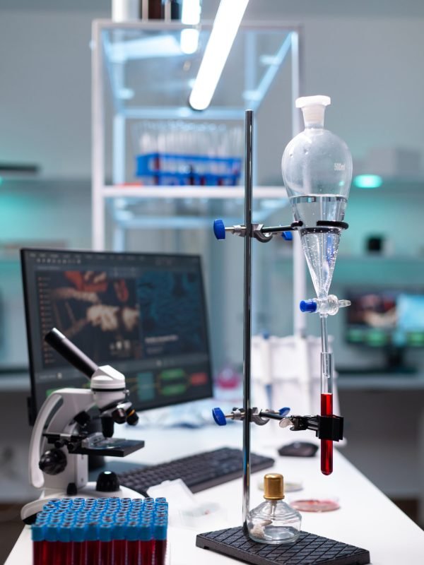 Science laboratory equipment and test tube with blood for healthcare development. Chemical dripping pipe with glass flask for analysis in biochemistry lab at clinic. Professional instruments